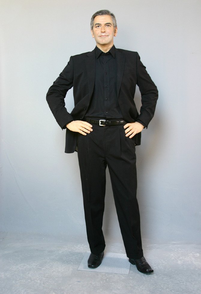 Full-length view of George Clooney wax figure in black suit for exhibition display.