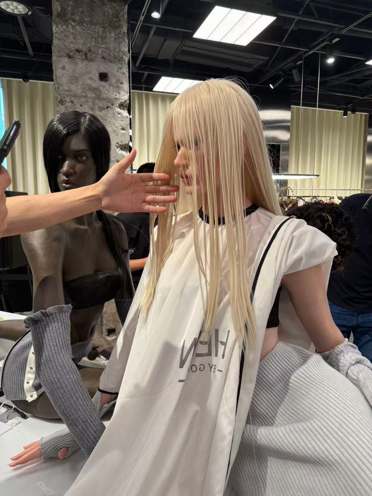 Wax figure artist arranging long blonde hair during production