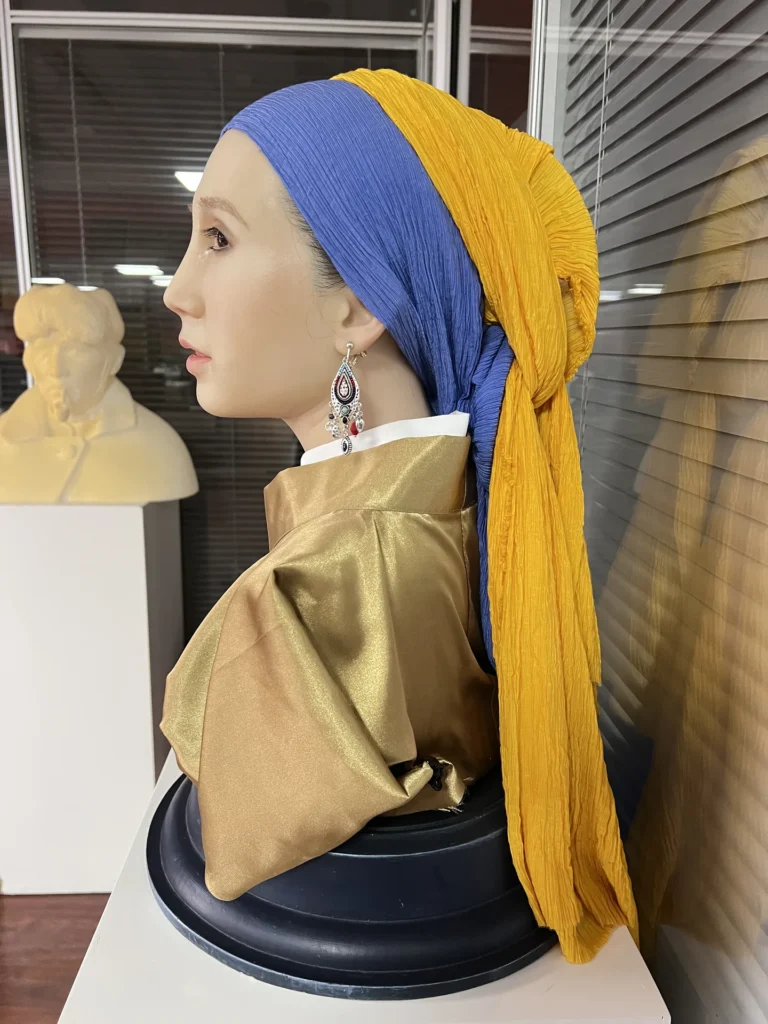 Girl with a Pearl Earring wax bust displayed on a pedestal.