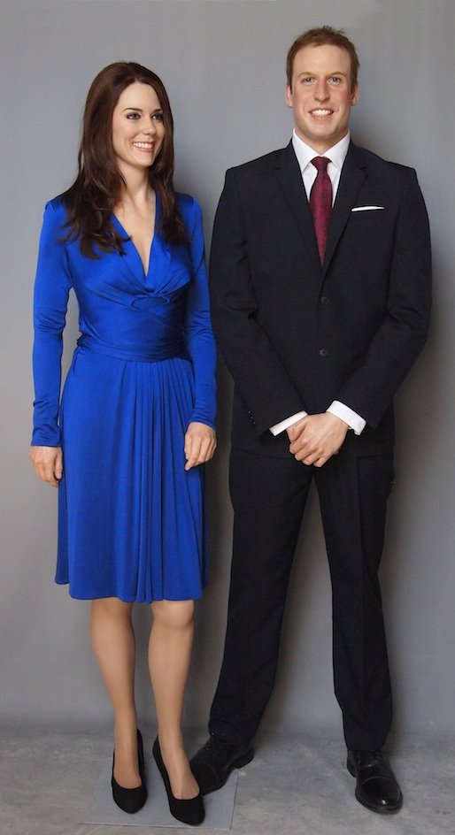Prince William and Kate Middleton wax figures arranged for indoor museum display.