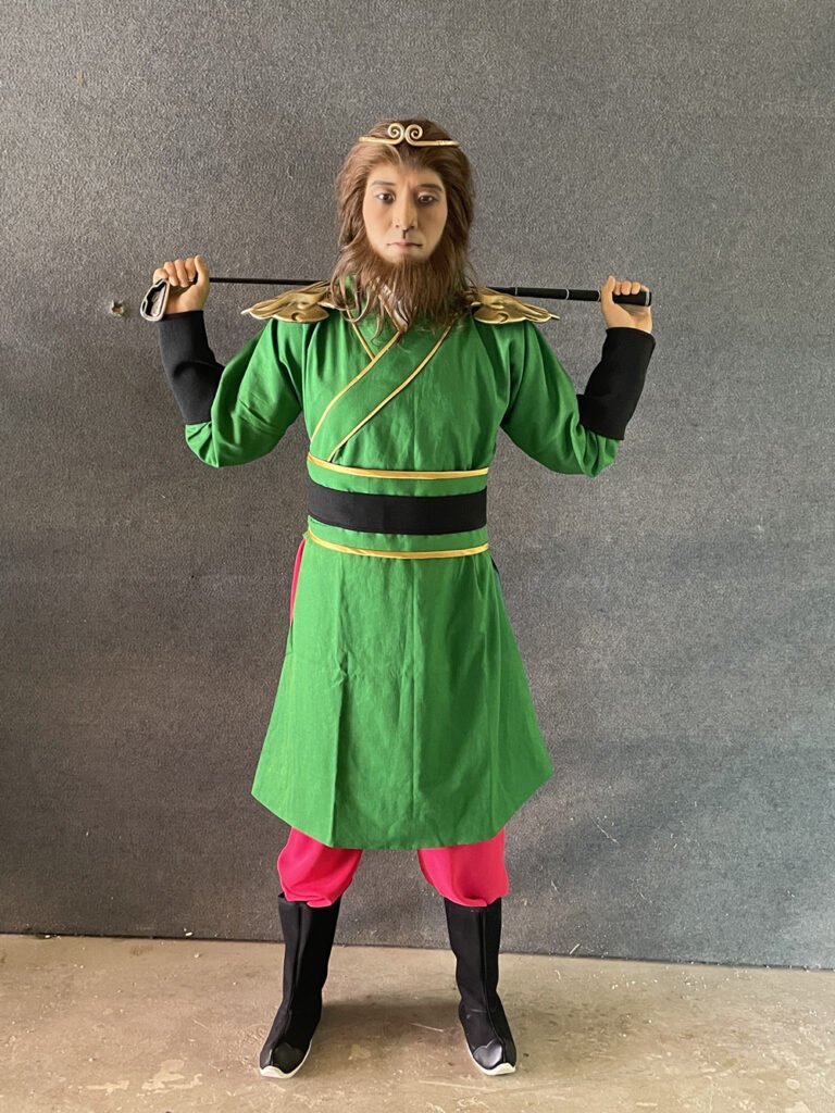 Full-length view of Sun Wukong Monkey King wax figure in green warrior outfit for museum display.