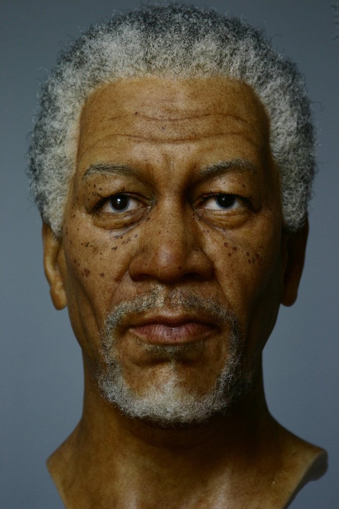 Extreme close-up view of Morgan Freeman wax figure showing realistic freckles and facial texture.